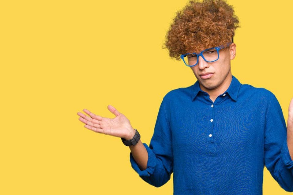 Confused man standing with yellow background