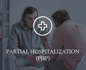 A counselor is speaking to a Prosperity Haven patient, with the words "PARTIAL HOSPITALIZATION" overtop of the photo.