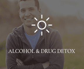 A young guy wearing a jacket is smiling into the camera with "ALCOHOL & DRUG DETOX" written overtop of the photo.