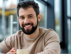 Man smiling in a tan sweatshirt