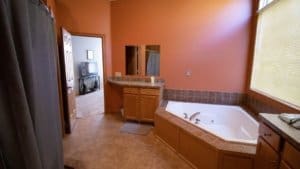 A men's only rehab facility with a bathroom featuring a jacuzzi tub and a window.