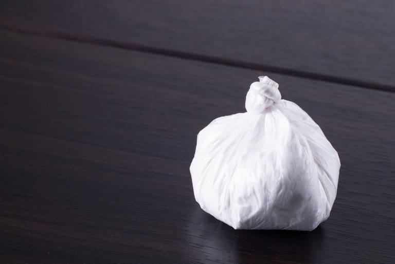 A white bag sitting on top of a wooden table in an addiction recovery center.