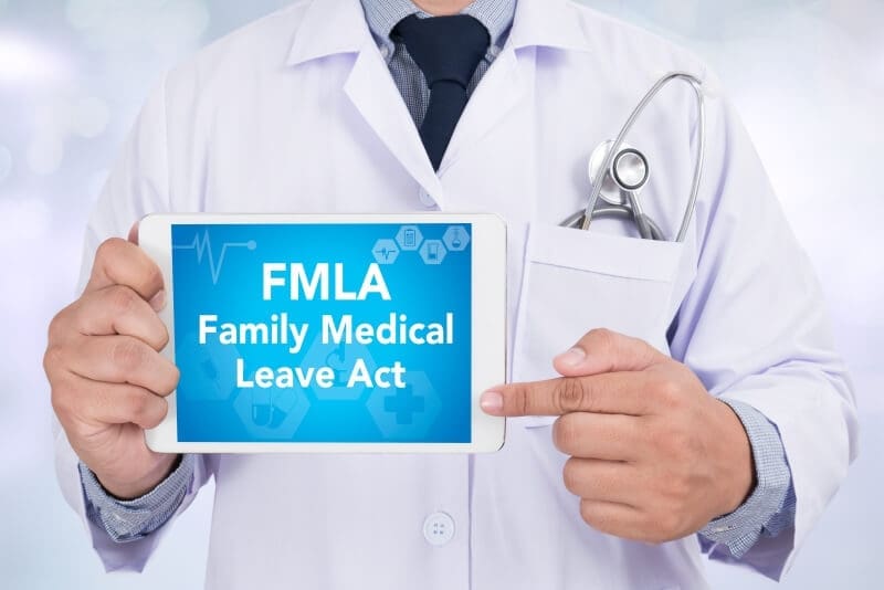A doctor at an addiction recovery center holding up a tablet with the text fmla family medical leave act.