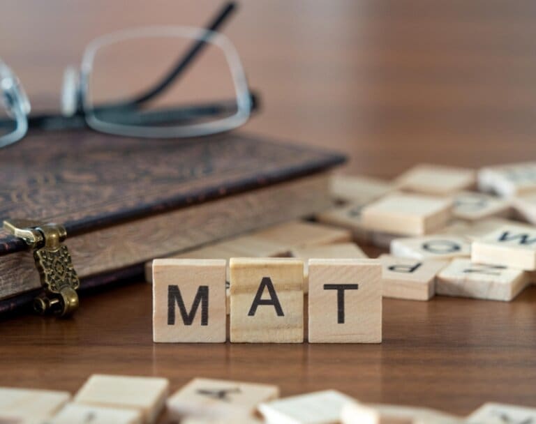 The word tam spelled out in wooden blocks on a wooden table at an inpatient treatment center.